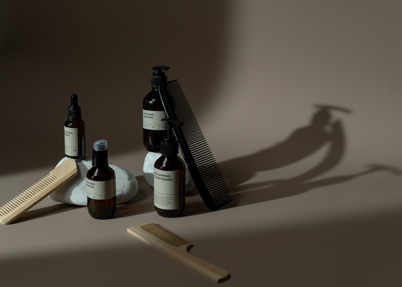 about-01 Minimalist display of beauty products, combs, and natural elements on a neutral background.